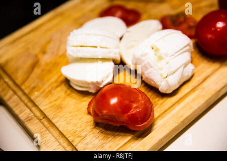 Mozzarella e pomodoro su un tagliere di legno Foto Stock