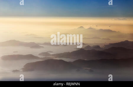 Elevata veduta aerea achipelago delle isole intorno a Hong Kong e a Lantau coperto dalle nuvole e la nebbia durante il tramonto ora.