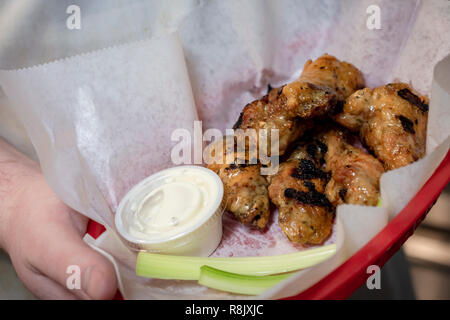 Cesto di ali di pollo con salsa di immersione e sedano. Solo a mano. Foto Stock