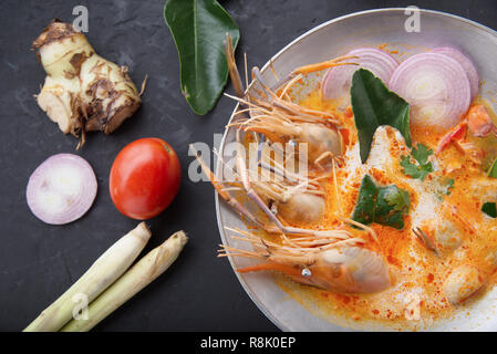 Tom Yam kong o Tom Yum, Tom Yam è una piccante minestra chiaro tipico in cucina thailandese. Tom Yam kong sul tavolo di legno. Cibo tailandese. Foto Stock