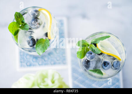 Bevande, cocktail e celebrazione il concetto di stile - cocktail con ghiaccio di mirtilli e limone Foto Stock