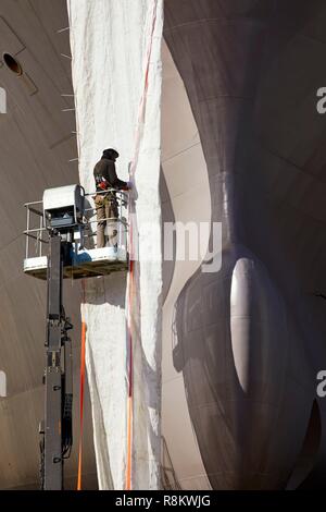 Francia, Finisterre, Concarneau, un lavoratore lungo la prua di una nave sullo scalo Foto Stock