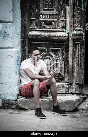Giovane uomo in attesa di passi in Havana Cuba Foto Stock