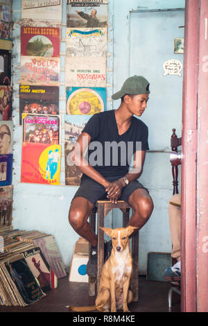 Giovane uomo con il cane che serve in archivio di record in Havana Cuba Foto Stock
