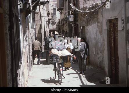 Scena di uno stretto vicolo affollato di pedoni e ciclisti in Damasco, Siria, Giugno 1994. () Foto Stock