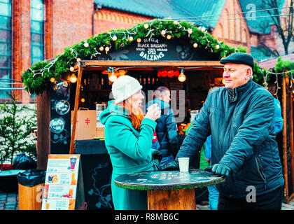 Riga, Lettonia - 28 dicembre 2016: giovane bevendo un vin brulé al mercatino di Natale a Riga in Lettonia in inverno. Foto Stock