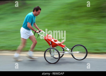 Padre che fa jogging con sua figlia nel passeggino, USA 1992 Foto Stock