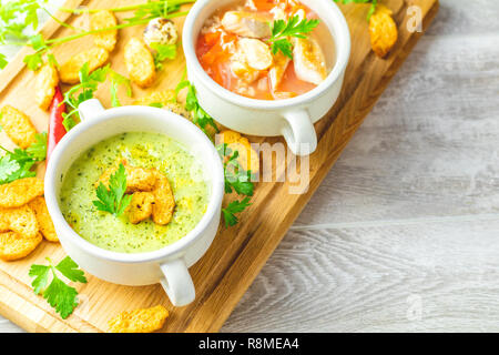 Concetto di sana le zuppe di verdure e legumi. Minestra di verdura con la carota, uova e carne di pollo, crema di funghi zuppa con erbe e cracker e ingredie Foto Stock