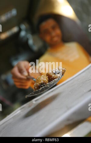 Pasticceria locale chef a Tunisi offre un pezzo di dolci il suo vende, come un gesto di benvenuto in città. Foto Stock