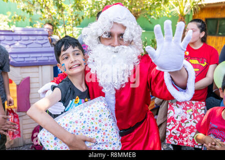 Babbo Natale dando presenta durante il periodo di Natale per i bambini del Norte Pudahuel Scuola Speciale Amazing felicità facce, emozioni e wishful thinkings Foto Stock