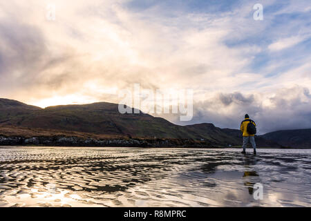 Ardara, County Donegal, Irlanda. 16 dicembre 2018. Un viandante prende alla spiaggia in un freddo e ventoso pomeriggio dopo le tempeste hanno superato. Credito: Richard Wayman/Alamy Live News Foto Stock