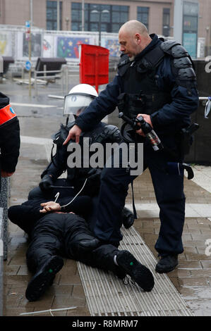 Bruxelles, Belgio. Xvi Dec, 2018. Poliziotti armati arresto di un manifestante durante il 'Marco contro Marrakech " rally di fronte alle istituzioni dell' Unione europea con sede a Bruxelles, Belgio, Dic 16, 2018. Belga anti-immigrazione manifestanti hanno percorso le strade di Bruxelles qui la domenica per denunciare il Global Compact per sicuro, ordinato e regolare la migrazione adottata a Marrakech, Marocco. Credito: Voi Pingfan/Xinhua/Alamy Live News Foto Stock