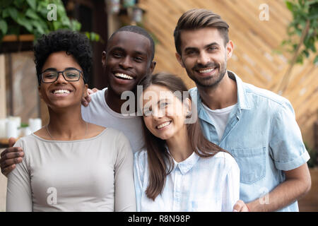 Colpo alla testa ritratto di felice multietnica amici guardare la fotocamera Foto Stock