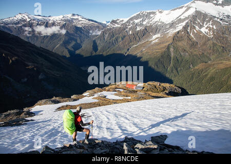 Escursionista nella neve sopra cresta francese capanna, Mt Aspiring National Park, Nuova Zelanda Foto Stock