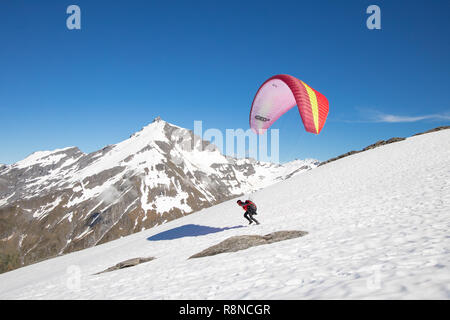 Lancio di parapendio off montagne innevate, Nuova Zelanda Foto Stock
