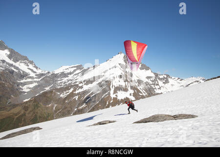 Lancio di parapendio off montagne innevate, Nuova Zelanda Foto Stock