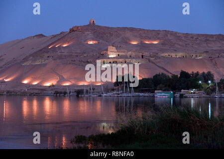 Vista serale delle tombe dei nobili, antiche tombe rupestri di alti funzionari della Corte egiziana su di una collina che si affaccia sul Nilo ad Aswan Egitto. Foto Stock