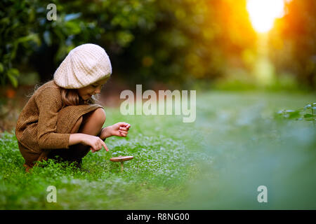 La bambina nella foresta e toadstools Foto Stock