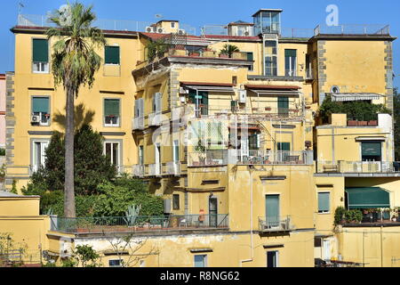 Multi-storia giallo casa mediterranea con terrazze e tetto piatto sulla costa del mare di Napoli in Italia. Foto Stock