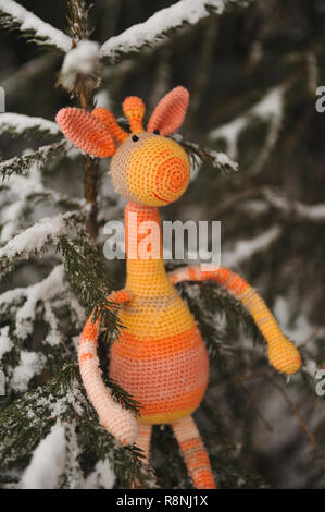 SYKTYVKAR, Russia - 16 dicembre 2018: immagine illustrativa. Appoggio la giraffa giocattolo in maglia la tecnica di maglieria amigurumi Foto Stock