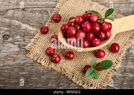 Mirtillo rosso con foglie di cucchiaio sul vecchio sfondo di legno Foto Stock