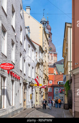 Street nel centro storico della città con la torre della cattedrale in background, Krāmu iela, Old Riga (Vecriga), Riga, Lettonia Foto Stock