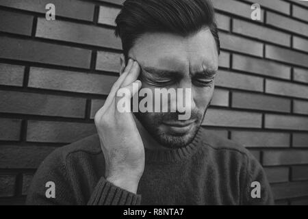 L'uomo sensazione emozioni dolorose, urlando, testimoniando la morte del caro amico, essendo miserabili e devastato, tenendo le palme sulla testa, urla di dolore un Foto Stock