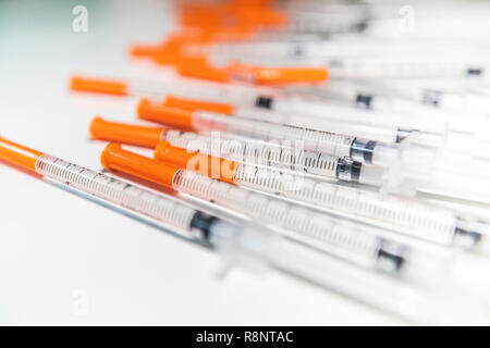 Immagine ravvicinata di un mucchio di insulina medicali Aghi con i cappucci arancioni Foto Stock