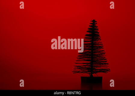 Una silhouette artificiale di pino su uno sfondo di colore rosso. Foto Stock