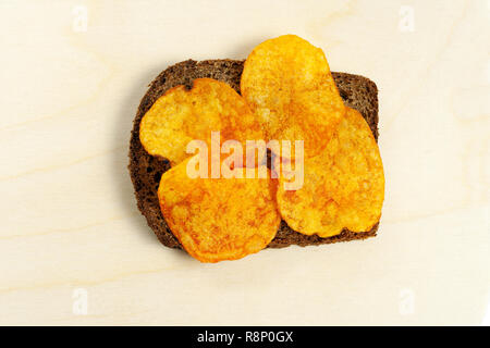 Pane con patate fritte. Close-up su uno sfondo di legno. Foto Stock