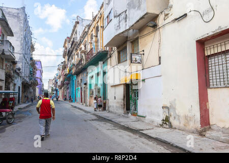 Uomo che cammina verso il basso old street in Havana Cuba Foto Stock