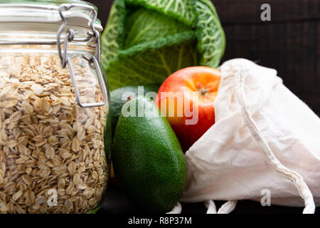 Rifiuti Zero a fare la spesa. Pacchetto-free food on dark tavolo in legno con texture. Frutta e verdura fresche in Eco borse in cotone. Plastica-pacchetto gratuito Foto Stock