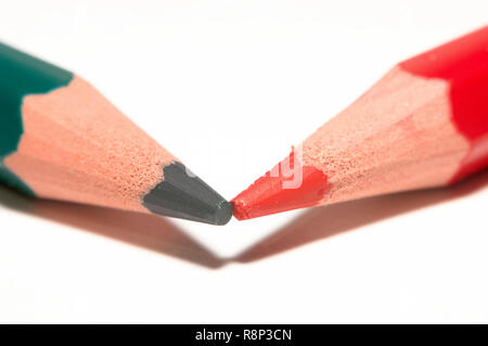 Macro di un verde e rosso e matita colorata, puntando insieme, isolato su carta bianca. Foto Stock