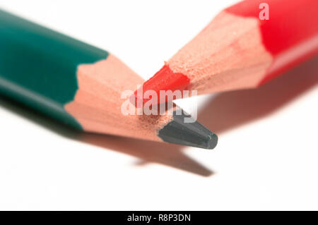 Macro di un verde e rosso e matita colorata, al di sopra di ogni altro, isolato su carta bianca. Foto Stock