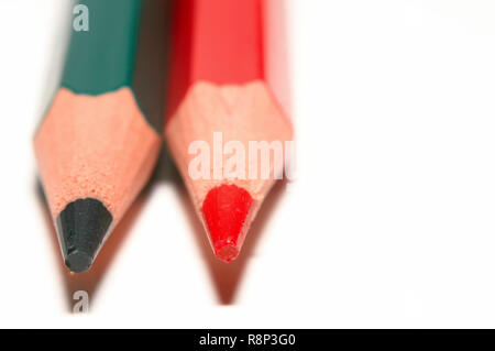 Macro di un verde e rosso e matita colorata, accanto a ciascun altro, isolato su carta bianca. Foto Stock