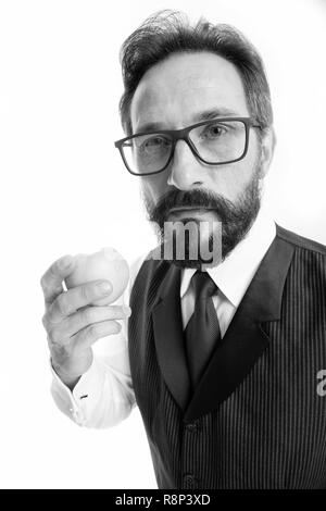 Guida per la prescrizione di occhiali con lenti e montature. Imprenditore classico abbigliamento formale e corretto eyewear detiene eat apple. Imprenditore occhiali formale scelta. Una sana visione vista nutrizione suggerimenti. Foto Stock