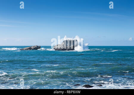 Onde che si infrangono e battenti spruzzare sulle rocce a PIEDRAS BLANCAS, San Simeone, CA, Stati Uniti d'America Foto Stock