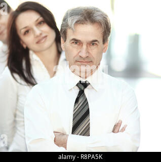 Leader e il team aziende dietro di lui. Foto Stock