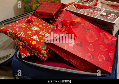 Tornare a casa per le vacanze di Natale con una valigia piena di regali. Foto Stock