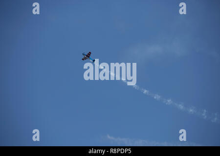 Piccolo aeroplano facendo acrobazie aeree in una mostra Foto Stock