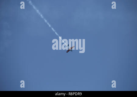 Piccolo aeroplano facendo acrobazie aeree in una mostra Foto Stock