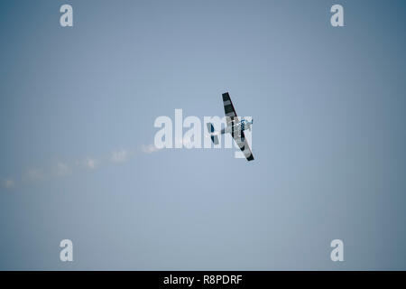 Piccolo aeroplano facendo acrobazie aeree in una mostra Foto Stock