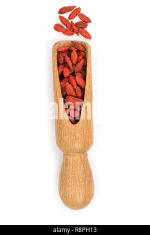 Essiccati goji bacche di scoop di legno isolato su sfondo bianco. Vista dall'alto. Lay piatto Foto Stock