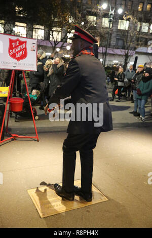 Esercito della salvezza soldato esegue per le collezioni in midtown Manhattan Foto Stock