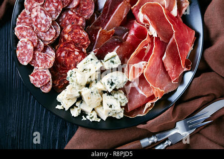 Vista aerea di un set di formaggio, spagnolo di salsicce e di salatura a secco la carne - jamon, chorizo, Formaggi a Muffa Blu cubs, affettato fuet salsicce su un piatto sul Foto Stock
