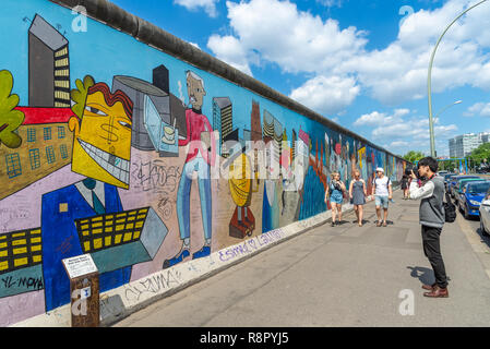 Turistica prendendo le foto presso il Muro di Berlino East Side Gallery di Berlino, Germania Foto Stock