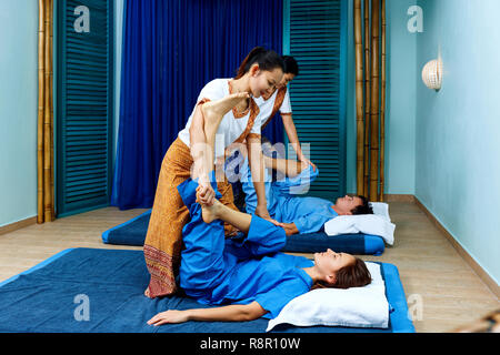 Due massaggiatrici tailandesi in modo sincrono facendo il massaggio thai. Foto Stock