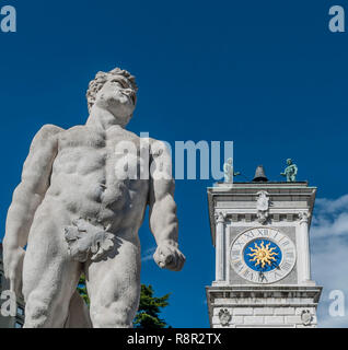 La statua di Ercole con la torre dell'orologio del San Giovanni colonnato di Piazza della Libertà, Udine, Friuli, Italia Foto Stock