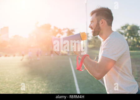 Il head coach urla al megafono. Gioco di calcio. Concetto Foto Stock