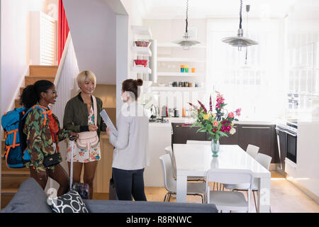 Agente immobiliare saluto di donne giovani amici arrivando a Affitto casa Foto Stock